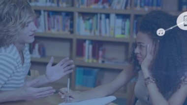 Animation of network of digital icons over diverse girl and boy studying in library at college. Global networking and education technology concept