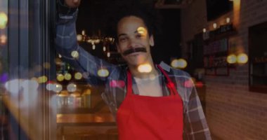 Animation of spots of light over man working in cafe. Global networks, business, finance, computing and data processing concept digitally generated video.