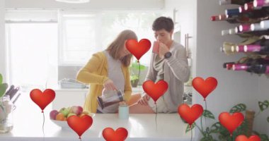 Animation of heart balloon emojis over happy caucasian female couple in love drinking coffee. Love, romance and celebration concept digitally generated video.