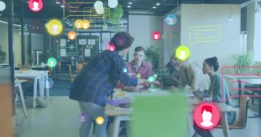 Animation of media icons over diverse business people working in office. Global business and digital interface concept digitally generated video.