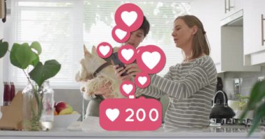 Animation of heart emojis and numbers over happy caucasian female couple in love. Love, romance and celebration concept digitally generated video.