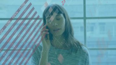 Animation of financial data processing over biracial businesswoman using smartphone. Global business, finances, computing and data processing concept digitally generated video.