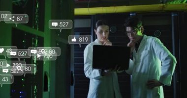 Animation of social media icons and numbers over diverse it technicians by computer server. Global business, finances, computing and data processing concept digitally generated video.