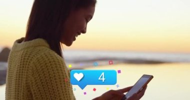 Animation of heart icon with increasing numbers over african american woman using smartphone. Social media networking and business technology concept