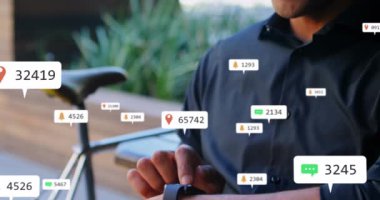 Animation of social media icons floating over caucasian man smiling while using smartwatch. Social media networking technology concept