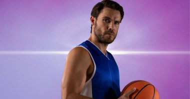 Composition of male basketball player holding basketball with copy space. sport and competition concept digitally generated image.