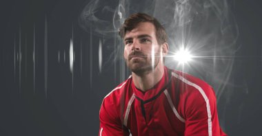 Caucasian male athlete against smoke effect and light spot on grey background. sports tournament and competition concept