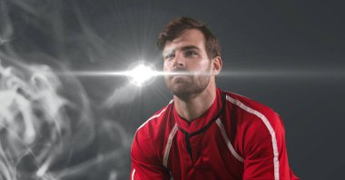 Caucasian male athlete against smoke effect and light spot on grey background. sports tournament and competition concept
