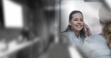 Composition of smiling businesswoman talking on smartphone in office with copy space. business, finances, success and communication concept digitally generated image.