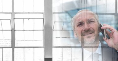 Composition of smiling businessman talking on smartphone in office with copy space. business, finances, success and communication concept digitally generated image.