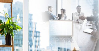 Composition of happy diverse business team shaking hands in meeting room with motion blur. global business, partnership and success concept digitally generated image.