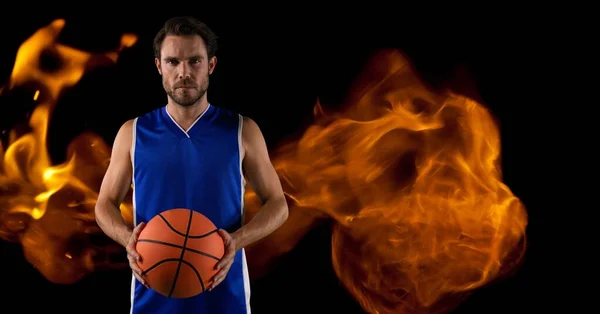 Composition Male Basketball Player Standing Holding Ball Flames Black Background — Stock fotografie