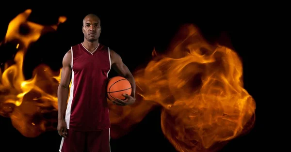 Composition Male Basketball Player Standing Holding Ball Flames Black Background — Stock fotografie