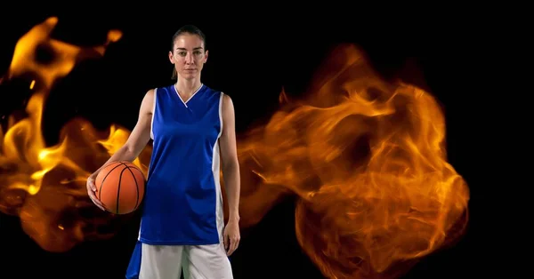 Composition Female Basketball Player Standing Holding Ball Flames Black Background — Stock fotografie