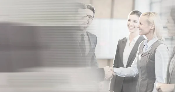 Composition of happy diverse business team shaking hands with motion blur. global business, partnership and success concept digitally generated image.