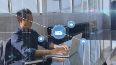 Animation of network of connections with icons over biracial businessman working at office. Global business, connections and digital interface concept digitally generated video.