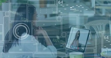 Animation of data processing against biracial woman having a videocall on laptop at office. Computer interface and business networking technology concept