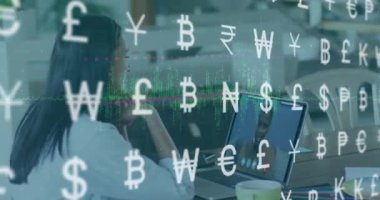 Animation of currency symbols against biracial woman having a videocall on laptop at office. Global economy and business networking technology concept