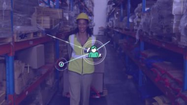 Animation of network of icons over african american female worker pulling a pallet at warehouse. Global networking and logistics business technology concept