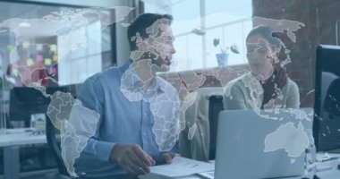 Animation of data processing and world map over diverse man and woman discussing at office. Computer interface and business technology concept