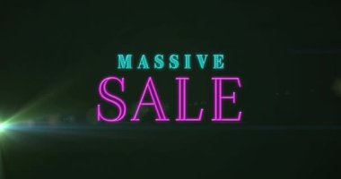 Animation of massive sale text banner against light spot on black background. Sale discount and retail business concept