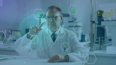 Animation of icon in hexagons over senior caucasian scientist swiping on futuristic screen in lab. Digital composite, multiple exposure, medical, healthcare, recycle and technology concept.