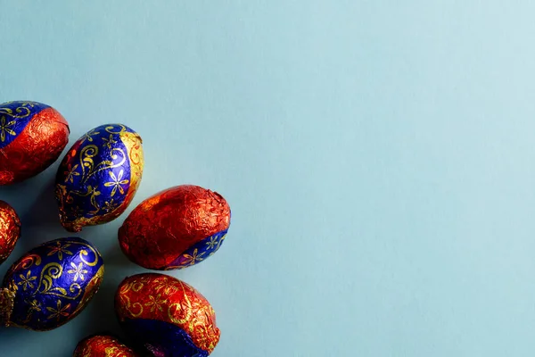 stock image Image of multi coloured chocolate easter eggs with copy space on blue background. Easter, religion, tradition and celebration concept.