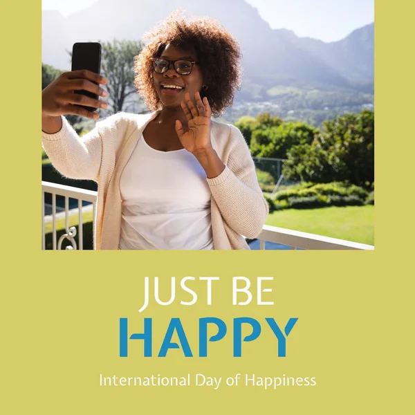 Mezinárodní Den Štěstí Text Nad Šťastný Africký Američan Žena Smartphone — Stock fotografie