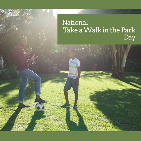 National take a walk in the park day text over african american father and son playing football. National take a walk in the park day and celebration concept digitally generated image.