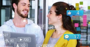 Ofisteki dizüstü bilgisayara gülümseyen kadın ve erkeğin sosyal medya simgelerinin animasyonu. Sosyal medya ağı ve iş teknolojisi kavramı