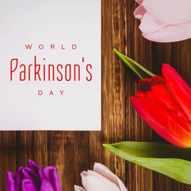 World Parkson 's Day metninin ve ahşap masada renkli çiçeklerin birleşimi, kopyalama alanı. Farkındalık, sinir sistemi, doğa, kampanya, sağlık, destek ve önleme kavramı.