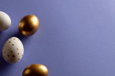 Çoklu renkli paskalya yumurtaları ve mor arkaplanda fotokopi alanı. Paskalya, din, gelenek ve kutlama kavramı.