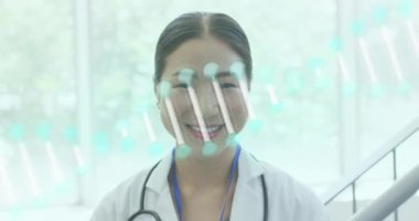 Hastanede çalışan çeşitli gülümseyen doktorların portresinin üzerindeki DNA iplikçiklerinin animasyonu. Dijital olarak üretilen tıbbi ve sağlık hizmetleri kavramı.