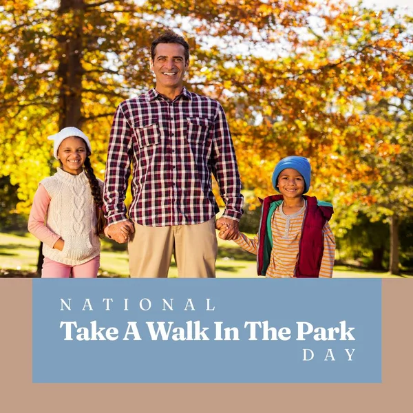 National take a walk in the park day text over happy diverse father with children in park. National take a walk in the park day and celebration concept digitally generated image.