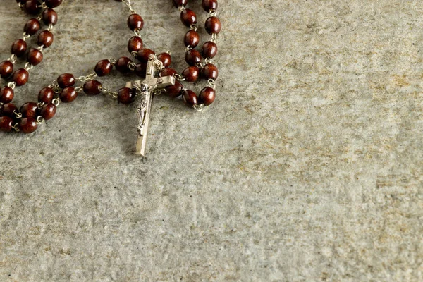 Image of close up of rosary and copy space on stone background. Easter, religion, tradition and celebration concept.