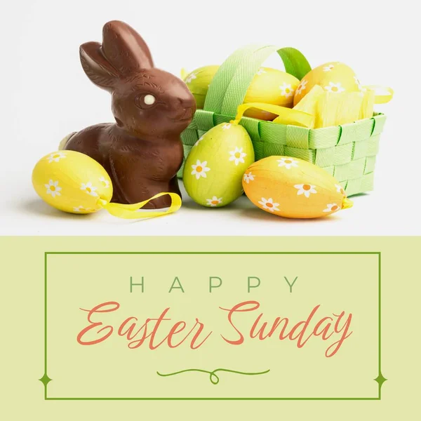 Image of happy easter sunday text over chocolate rabbit and easter eggs. Easter sunday and celebration concept digitally generated image.