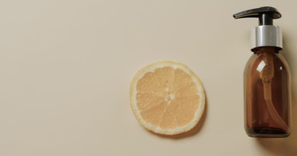Close Skleněné Láhve Čerpadlem Citron Plátek Kopírovat Prostor Béžové Pozadí — Stock video