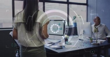 Animation of data processing over biracial businesswoman working in office. Global business, finances, computing and data processing concept digitally generated video.