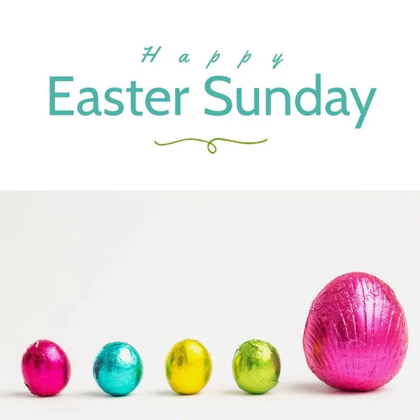 Image of happy easter sunday text over chocolate easter eggs and copy space. Easter sunday and celebration concept digitally generated image.