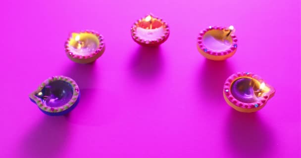 紫色の背景でディワリを祝うカラフルなキャンドルを燃やすことの終わり ディワリ 伝統とお祝いの概念 — ストック動画