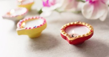 Diwali 'yi beyaz arka planda kutlayan renkli mumları yakın. Diwali, gelenek ve kutlama konsepti.