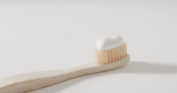 コピースペースと白い背景に歯磨き粉で歯ブラシの閉じる プラスチックフリー美しさとエコパッケージコンセプト — ストック動画