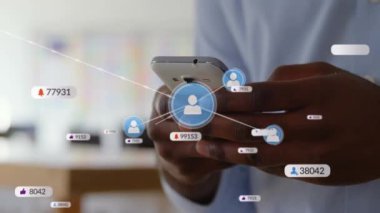 Akıllı telefon kullanan Afro-Amerikan adam üzerinden medya simgelerinin ve numaraların animasyonu. Dijital olarak oluşturulmuş küresel sosyal medya, finans, hesaplama ve veri işleme kavramı.