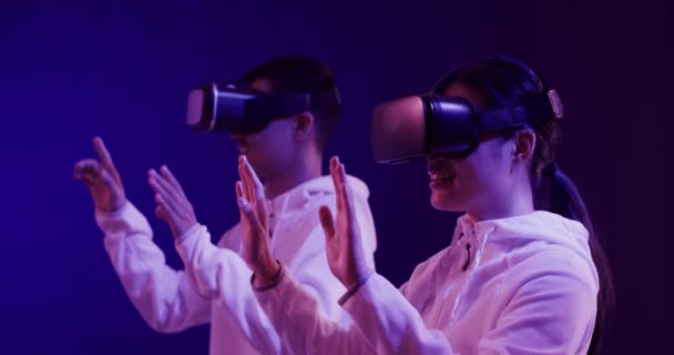 亚洲男人和女人使用Vr耳机 触摸蓝色背景的虚拟屏幕 动作缓慢 虚拟现实和元概念 — 图库视频影像