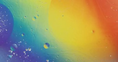 Mavi, sarı ve turuncu sıvı üzerinde hareket eden kabarcıkların canlandırılması. Desen, hareket ve renk konsepti dijital olarak oluşturulmuş video.