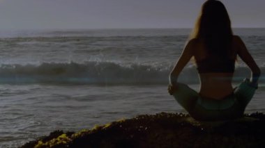 Kafkasyalı bir kadının plajda yoga ve meditasyon yapması üzerine hafif noktaların canlandırılması. Küresel spor ve dijital arayüz kavramı dijital olarak oluşturulmuş video.