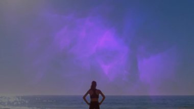 Plajda elleri belinde, beyaz bir kadının üzerinde mor şekillerin canlandırılması. Küresel spor ve dijital arayüz kavramı dijital olarak oluşturulmuş video.