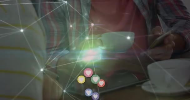 在咖啡店用智能手机对心形图标进行动画 并在话音人身上建立连接网络 社交媒体联网技术概念 — 图库视频影像