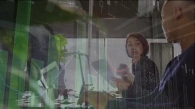 Animation of financial data processing over diverse business people working in office. Global business, finances, computing and data processing concept digitally generated video.