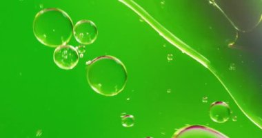 Fotokopi alanı olan pembe ve yeşil arka planda hareket eden baloncukların canlandırması. Desen, hareket ve renk konsepti dijital olarak oluşturulmuş video.